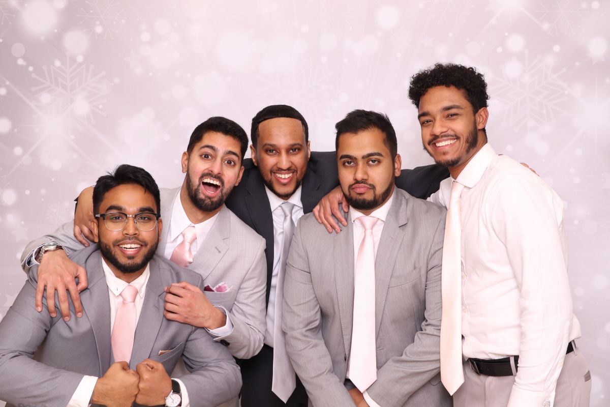 Friends posing together at photo booth event